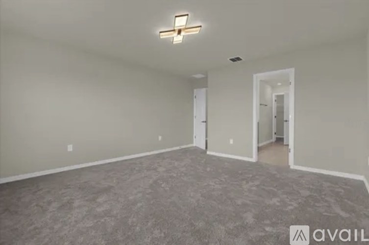 A room with a carpeted floor and a light fixture on the ceiling.