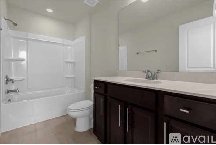 A white bathroom with a toilet, sink, and bathtub.
