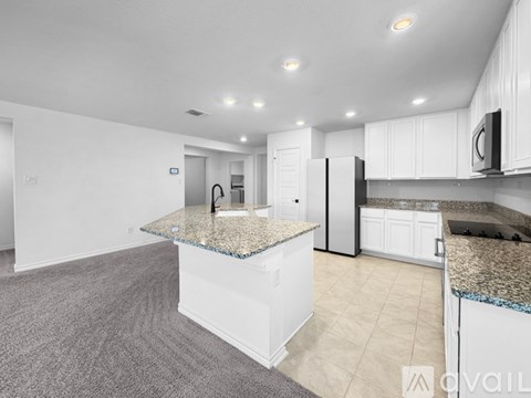 A kitchen with white cabinets and a granite countertop.