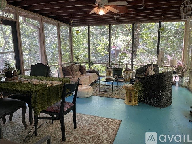 A living room with a table and chairs and a ceiling fan.
