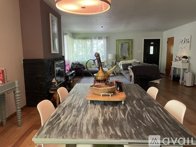 A dining table with a wooden top and a marble pattern is surrounded by white chairs.