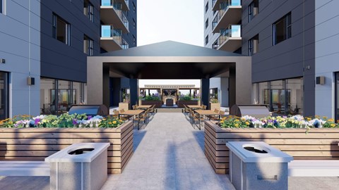 A modern building entrance with a walkway and flower beds on either side.