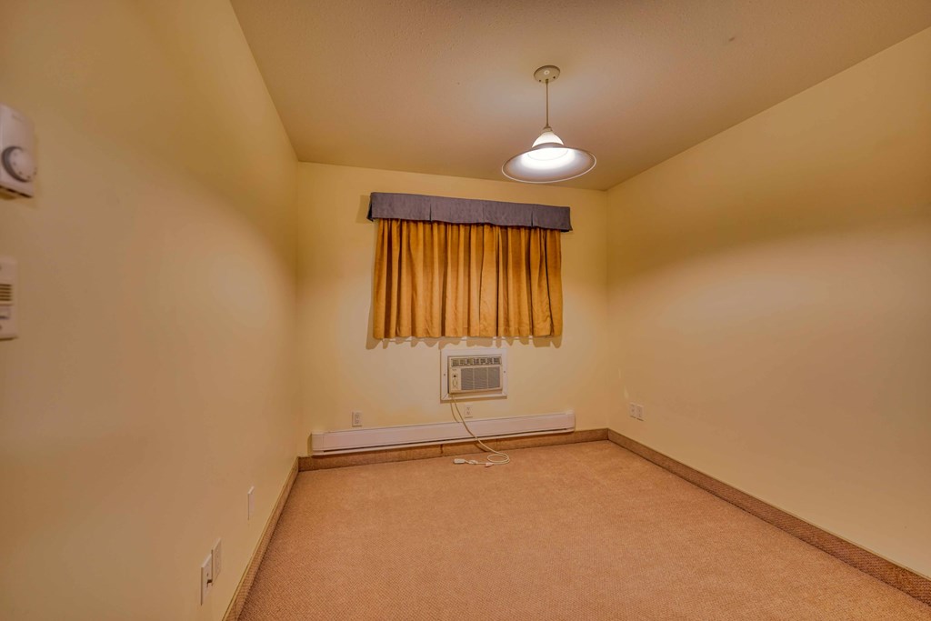 A room with a window covered by a yellow curtain.