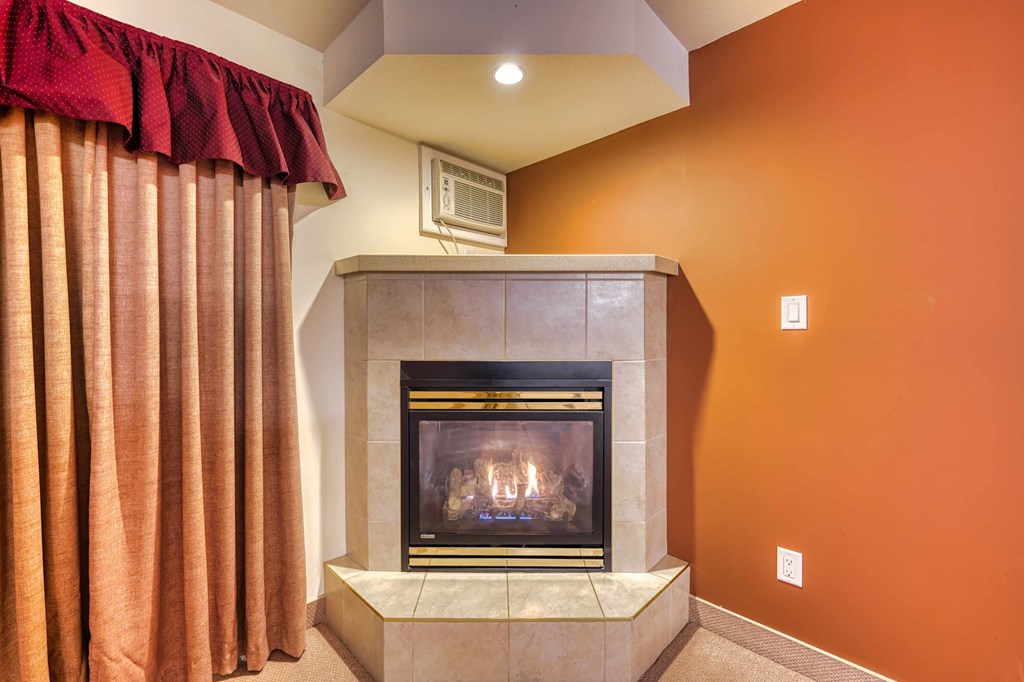 A fireplace with a red curtain on the left side.
