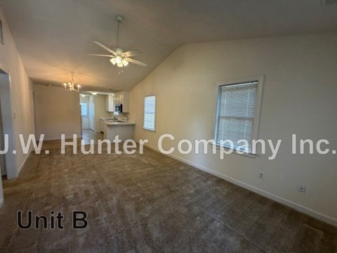 A spacious room with a ceiling fan and a window with blinds.