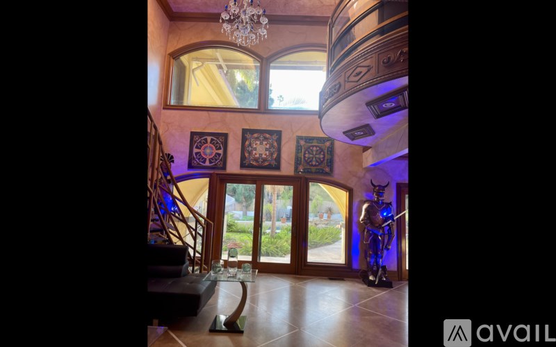 A room with a staircase and a chandelier.