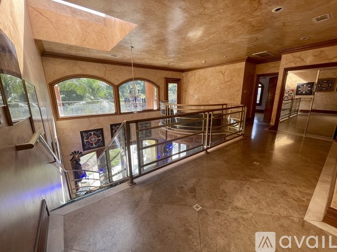 A spacious interior with a glass railing and a skylight.
