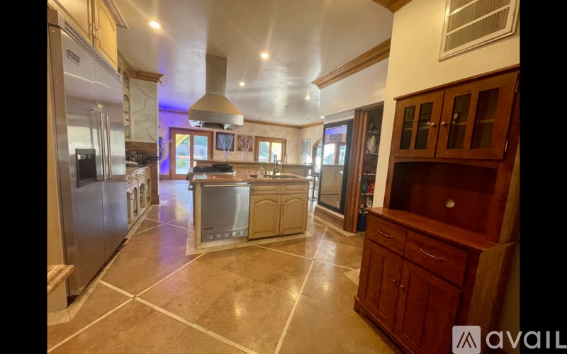 A kitchen with a refrigerator, oven, and cabinets.
