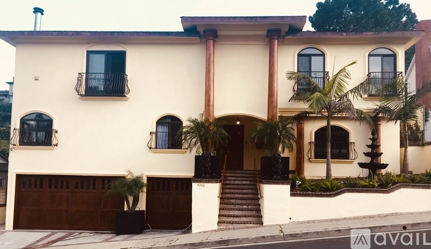 A two-story house with a balcony on the second floor.