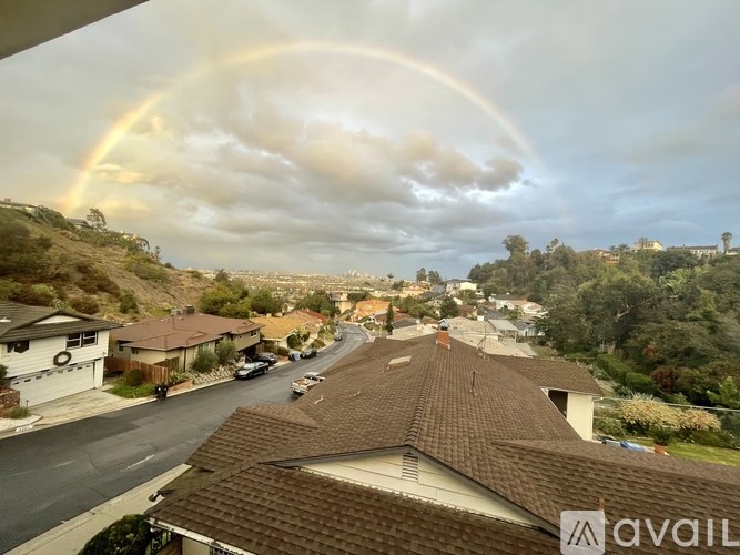 A rainbow appears over a residential street.