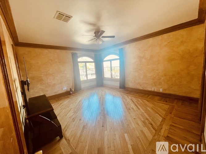 A room with wooden flooring and a ceiling fan.