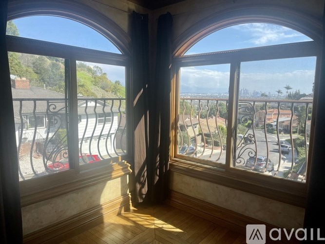 A balcony with a view of a street and houses.