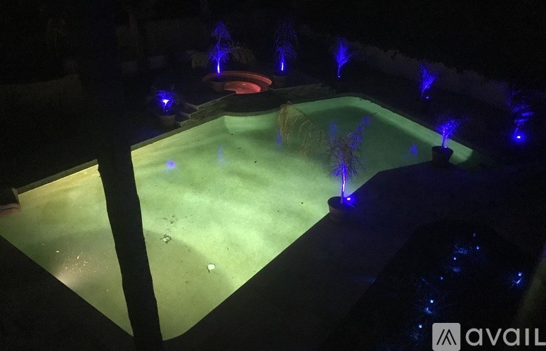A pool with blue lights and a red frisbee in the middle.