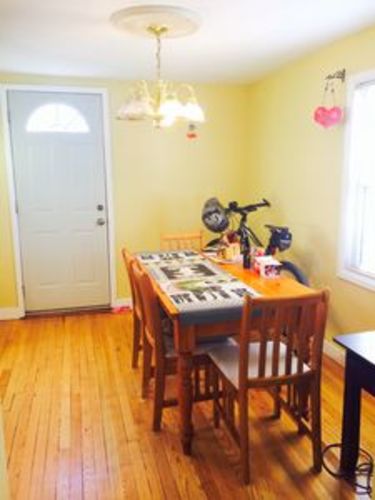 A dining room with a wooden table and chairs.