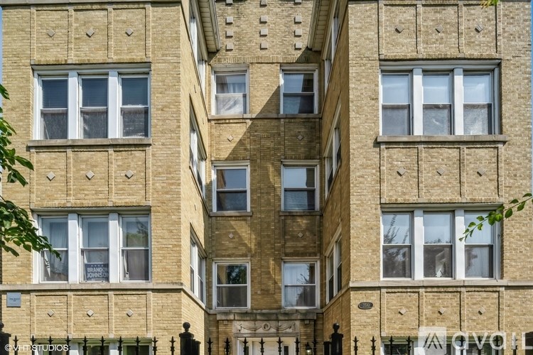 A tall building with many windows and a balcony with a railing.
