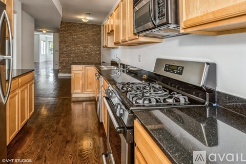 A kitchen with wooden cabinets and a black stove top.