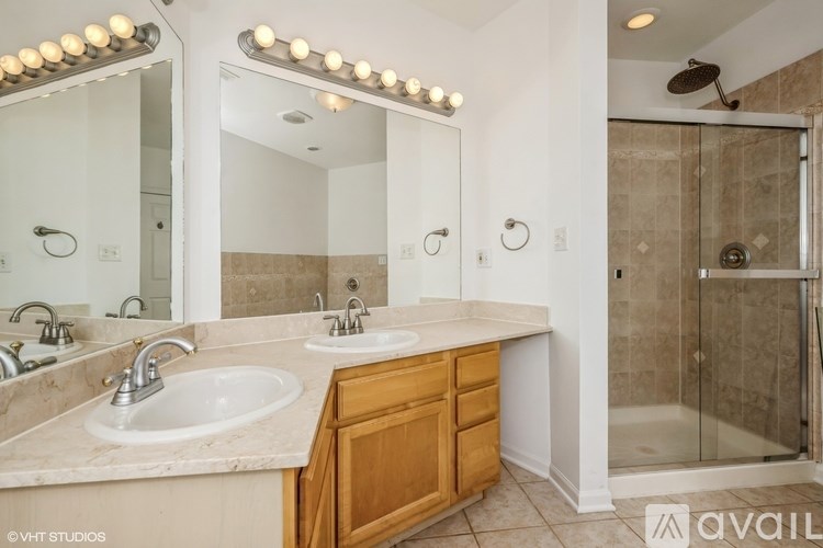 A bathroom with a vanity, mirror, and shower.