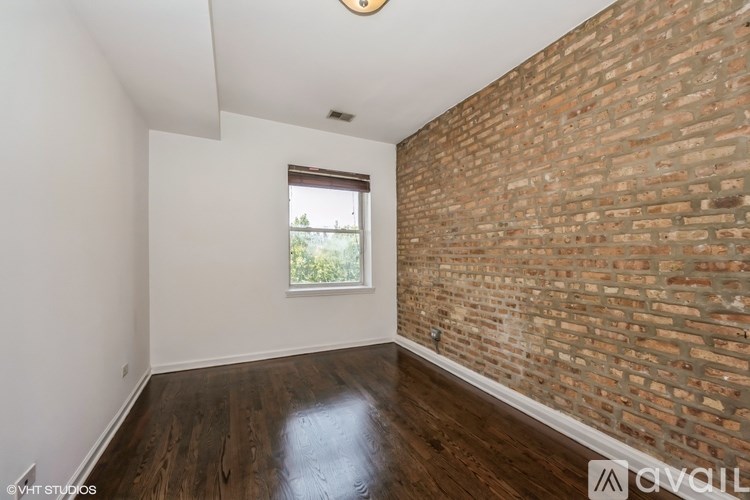 A room with a brick wall and wooden floor.