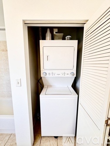A white washing machine is in a small closet.