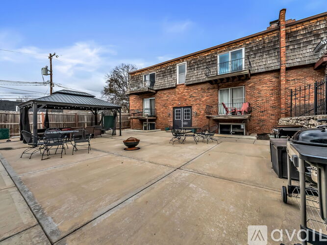 A patio area with a table and chairs is in front of a brick building.