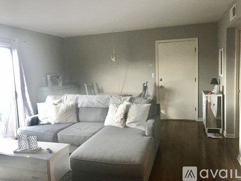 A living room with a grey couch and a white coffee table.