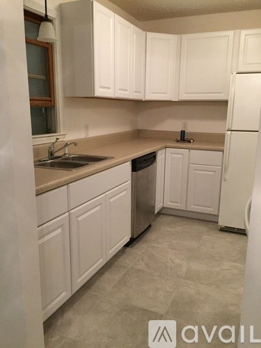 A kitchen with white cabinets and a white refrigerator.