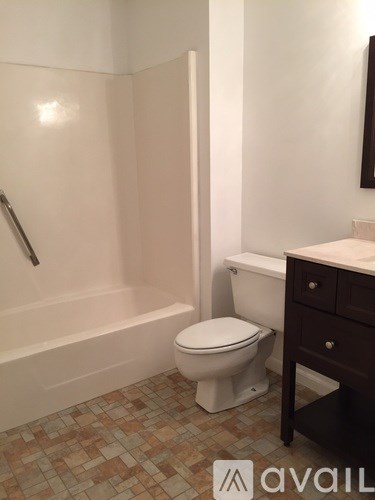 A white toilet sits next to a bathtub in a bathroom.