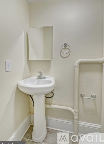 A white pedestal sink in a small bathroom.
