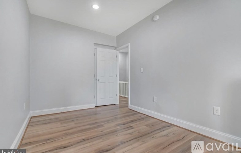 A room with wooden flooring and a white door.