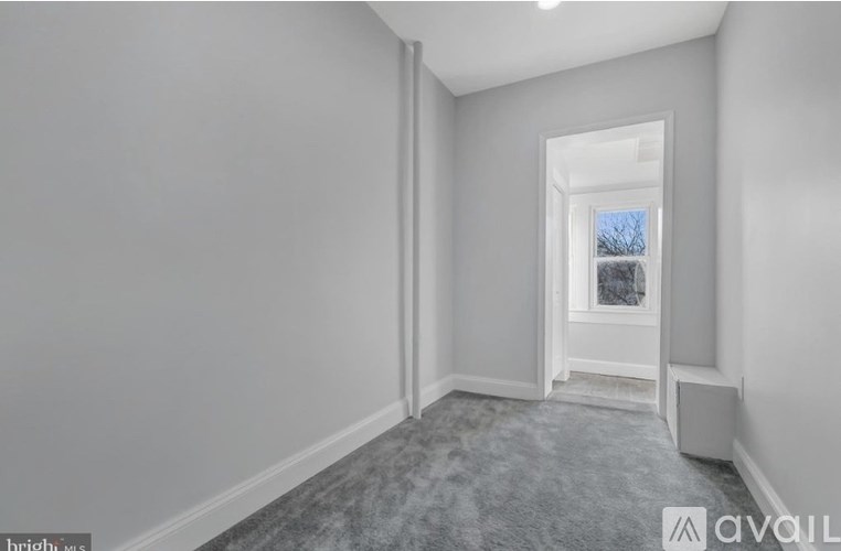A room with a carpeted floor and a window showing a snowy scene outside.