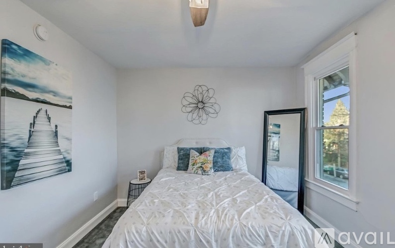 A bedroom with a large bed and a painting on the wall.