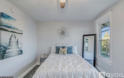 A bedroom with a large bed and a painting on the wall.