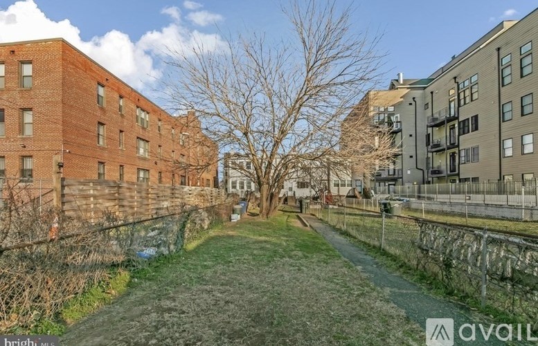 A pathway leads through a grassy area between two buildings.