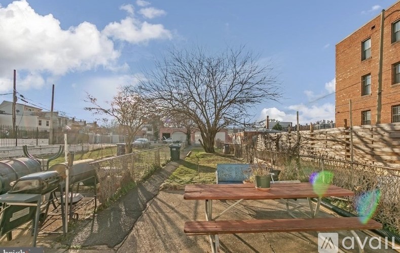 A backyard with a picnic table and a tree.