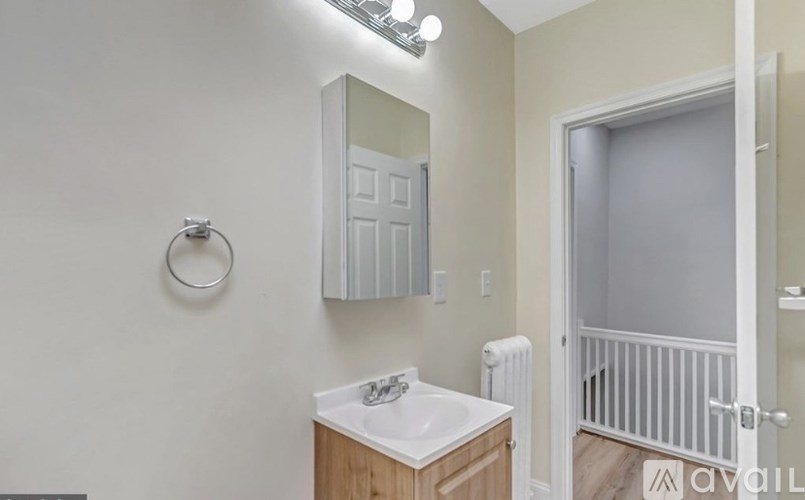 A bathroom with a sink, mirror, and towel rack.