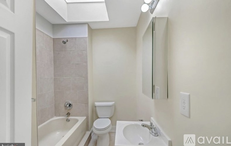 A bathroom with a toilet, sink, and bathtub.