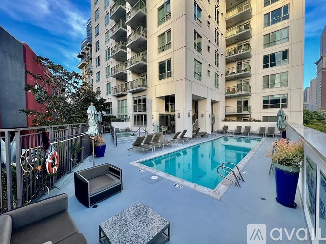 A large outdoor pool area with lounge chairs and a statue.
