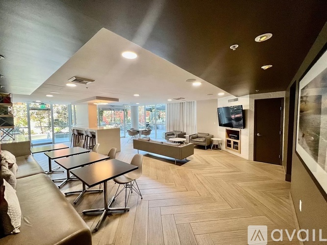 A living room with a couch, chairs, and a television.