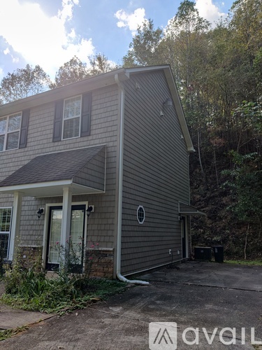 A grey house with a black door and windows.
