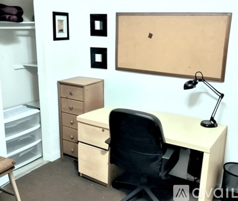 A room with a desk, chair, and a cabinet.