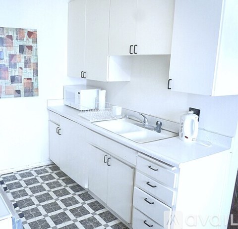 A white kitchen with a sink and a toaster.