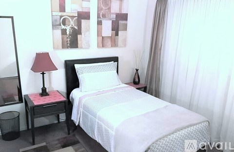 A bedroom with a bed, nightstand, and lamp.