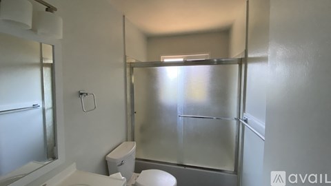 A bathroom with a toilet, sink, and shower.