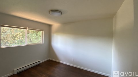 A room with a window and a wall-mounted heater.