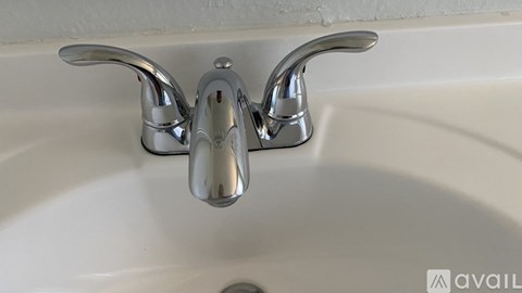 A white sink with a chrome faucet.
