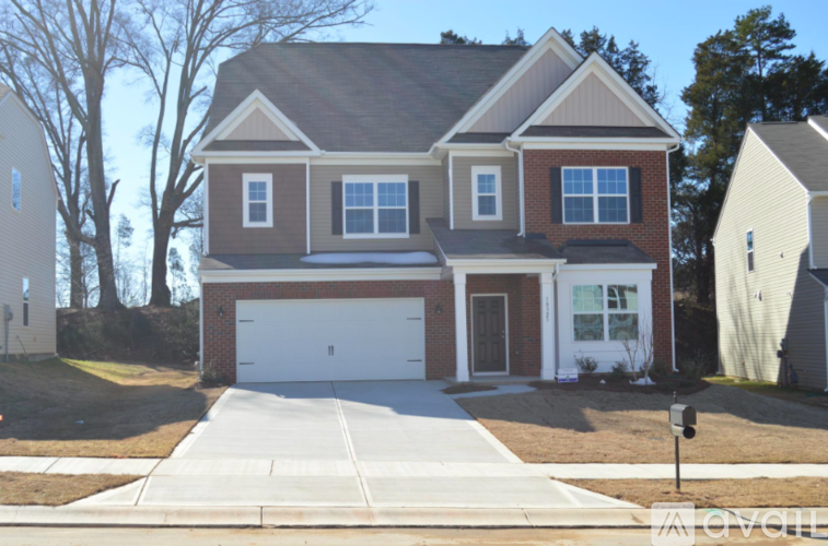 A two-story house with a garage is situated in a residential area.
