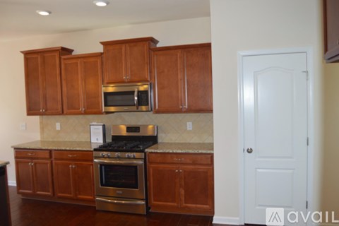 A kitchen with wooden cabinets and a stainless steel oven.
