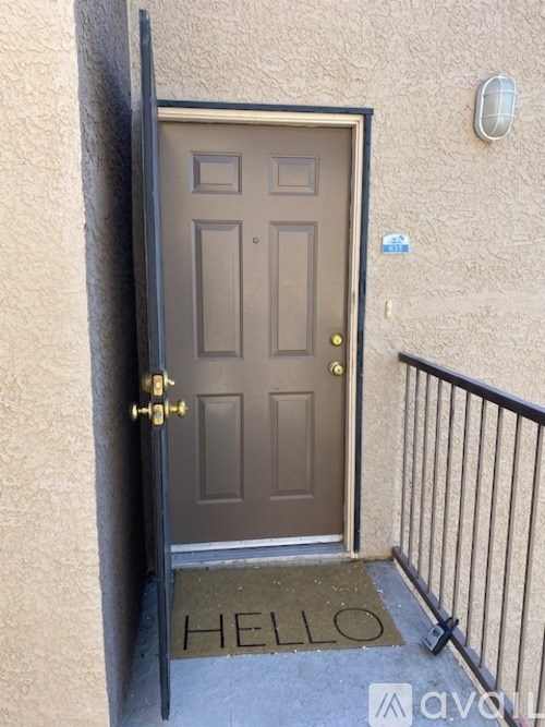 A brown door with a gold handle and a black railing.