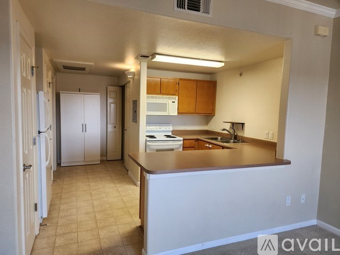 A kitchen with white cabinets and a brown countertop.