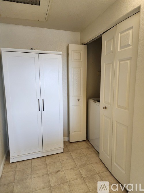 A white double door cabinet is in a room with a white door.